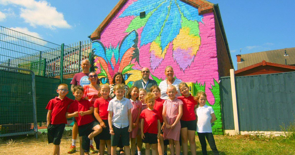 Pupils join artist to put art and soul into vibrant mural on side of their school